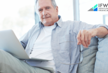 An image of a senior person in a business suit working on a laptop, representing the concept of working after retirement as discussed in the Institute of Financial Wellness' tips for success.