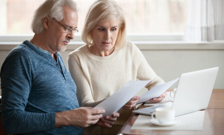 Serious worried senior couple calculating bills to pay or checking domestic finances stressed of debt, retired elderly old family reading documents concerned about loan bankruptcy money problems