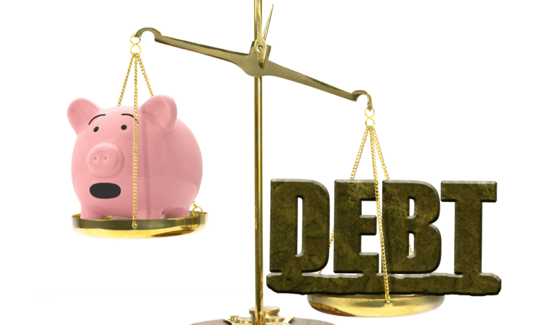 Debt on a scale with piggy bank (1)